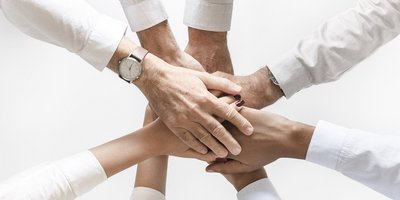 Hände vereint: Zusammenarbeit und Teamgeist in Aktion Acht Hände die sich in der Mitte berühren