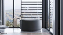 Ein modernes Badezimmer mit einer runden Badewanne, großen Fenstern und einem atemberaubenden Blick auf die Landschaft.
